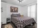 Comfortable bedroom with a patterned bedspread, world map wall decor, and hardwood floors at 3021 Botany St, Charlotte, NC 28216