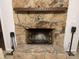 Stone fireplace with brass fire tools and a wooden mantle at 3333 Audrey Dr, Gastonia, NC 28054