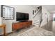 Living room featuring a mid-century modern media console and staircase at 414 W Tremont Ave, Charlotte, NC 28203