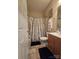 Cozy bathroom with a shower/tub combo, decorative shower curtain and wood cabinet at 5421 Roberta Meadows Ct, Concord, NC 28027