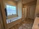 Bright bathroom featuring a large tub, glass shower, and tile flooring at 5421 Roberta Meadows Ct, Concord, NC 28027