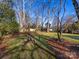 Large backyard with fire pit and mature trees at 6412 Wheeler Dr, Charlotte, NC 28211