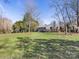 Spacious backyard with grassy lawn, deck, and mature trees at 6412 Wheeler Dr, Charlotte, NC 28211