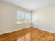 Simple bedroom with hardwood floors and a window at 6412 Wheeler Dr, Charlotte, NC 28211