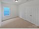 Well-lit bedroom with double doors and neutral carpeting at 744 Bartram Ave, Concord, NC 28025