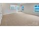 Large living room with neutral carpeting and multiple windows at 744 Bartram Ave, Concord, NC 28025