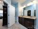 Bathroom features granite countertops, a double vanity, tile flooring, and a large mirror at 8177 Breton Way, Harrisburg, NC 28075