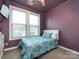 Bedroom with purple walls, and a window that provides natural light, with a ceiling fan at 8177 Breton Way, Harrisburg, NC 28075