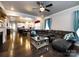 Open concept living room with hardwood floors, fireplace, and a modern ceiling fan at 8177 Breton Way, Harrisburg, NC 28075