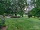 Landscaped backyard with lush greenery and golf course views at 9 Pine Tree Rd, Salisbury, NC 28144