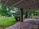 Brick patio with covered wooden trellis offering scenic backyard views at 9 Pine Tree Rd, Salisbury, NC 28144