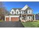 Two-story light beige house with a two-car garage and a covered front porch at Lot 113 Mayes Meadow Dr # Covington, Cornelius, NC 28078