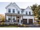 Two-story farmhouse with white siding, brown garage doors, and a front porch at Lot 113 Mayes Meadow Dr # Covington, Cornelius, NC 28078