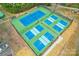 Aerial shot showcases several outdoor tennis courts with green and blue surfaces at 10506 Kenlauren Ter, Charlotte, NC 28210