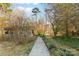 Scenic backyard with a long walking path, mature trees, and a swing at 1517 Cuthbertson Rd, Waxhaw, NC 28173