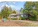 Charming single-story home featuring a covered front porch, mature landscaping, and a long gravel driveway at 1517 Cuthbertson Rd, Waxhaw, NC 28173