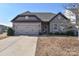 Curb appeal abounds in this charming one-story home featuring a two-car garage and stone accents at 152 Suggs Mill Dr, Mooresville, NC 28115