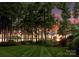Lush backyard with manicured lawn and mature trees offering stunning sunset views over the lake at 155 Union Chapel Dr, Mooresville, NC 28117