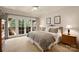Cozy bedroom features neutral colors, carpet, two end tables, and french doors to a balcony at 155 Union Chapel Dr, Mooresville, NC 28117