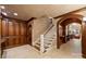 Hallway with wood paneling, tile floors, and stairs with white railings at 155 Union Chapel Dr, Mooresville, NC 28117