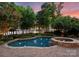 Backyard featuring a pristine pool, jacuzzi, brick patio, and lush landscaping with lake views at 155 Union Chapel Dr, Mooresville, NC 28117
