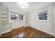 Bright bedroom with hardwood floors, two windows, and built-in shelving at 3515 Woodleaf Rd, Charlotte, NC 28205