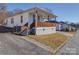 White house with wooden porch and gray brick base at 504 Washington St, Cramerton, NC 28032