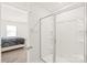 Bright bathroom with glass shower, ceramic tile, and bedroom doorway at 7324 Teague Dr, Gastonia, NC 28056