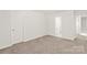 An empty bedroom with neutral carpet adjacent to bathroom at 7324 Teague Dr, Gastonia, NC 28056