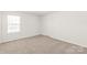 An empty bedroom with neutral carpet and one window offers a blank canvas for customization at 7324 Teague Dr, Gastonia, NC 28056