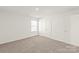 Bedroom with large windows, neutral carpet and door to a full bathroom at 7324 Teague Dr, Gastonia, NC 28056