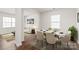 Open dining room with a table set for six, modern decor, hardwood floor and a view to the living room at 7324 Teague Dr, Gastonia, NC 28056