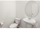Neat powder room with pedestal sink and an oval mirror at 7324 Teague Dr, Gastonia, NC 28056