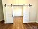 Stylish barn doors opening into a bright room with elegant wood flooring at 7667 Maple Bluff Ln # 53, Concord, NC 28025