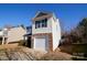 Two-story house with gray and beige siding, stone accents, and a two-car garage at 8224 Deodora Cedar Ln, Charlotte, NC 28215