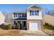 Two-story house featuring gray and beige siding, stone accents, and a two-car garage at 8224 Deodora Cedar Ln, Charlotte, NC 28215