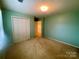 A simple bedroom features neutral carpet and walls, a double door closet, and two doorways at 1017 21St Ne Ave, Hickory, NC 28601