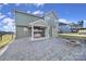 View of the backyard featuring a paver patio, fire pit, and covered porch with a swing at 1169 Hollis Sw Cir, Concord, NC 28025