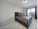 Cozy bedroom with a dark wood bed frame and plenty of natural light from a large window at 1169 Hollis Sw Cir, Concord, NC 28025