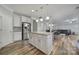 Open kitchen with a large center island, stainless steel refrigerator, and an adjacent living area at 1169 Hollis Sw Cir, Concord, NC 28025