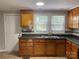 Well-lit kitchen featuring light brown cabinets, mosaic backsplash, and stainless steel sink at 1404 Linwood Rd, Gastonia, NC 28052