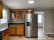 Bright kitchen featuring wooden cabinets, stainless steel refrigerator, and a connecting room at 1404 Linwood Rd, Gastonia, NC 28052