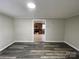 Living room featuring gray walls and flooring that looks into a kitchen with wooden cabinets and stainless appliances at 1404 Linwood Rd, Gastonia, NC 28052