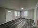Bright living room with modern gray wood flooring, freshly painted walls, and plenty of natural light at 1404 Linwood Rd, Gastonia, NC 28052