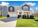 Charming two-story home featuring a well-manicured lawn, two-car garage, and inviting front porch at 14106 Magnolia Walk Dr, Huntersville, NC 28078