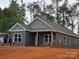 Charming one-story home with gray siding, a covered porch, and well-manicured landscaping at 211 Benfield Rd, Kings Mountain, NC 28086