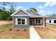 Charming single-story home with gray siding, wood accents, and a welcoming front porch at 211 Benfield Rd, Kings Mountain, NC 28086