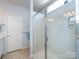 Shower with glass doors and white fixtures, door leading into bathroom visible at 21222 W Tern Ct, Fort Mill, SC 29707