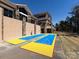 Outdoor shuffleboard courts with blue and yellow playing surfaces next to a clubhouse and trees at 21222 W Tern Ct, Fort Mill, SC 29707