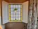 Close-up of stained glass window with white shutters in a bathroom with white tiling at 225 Wilson St, Albemarle, NC 28001